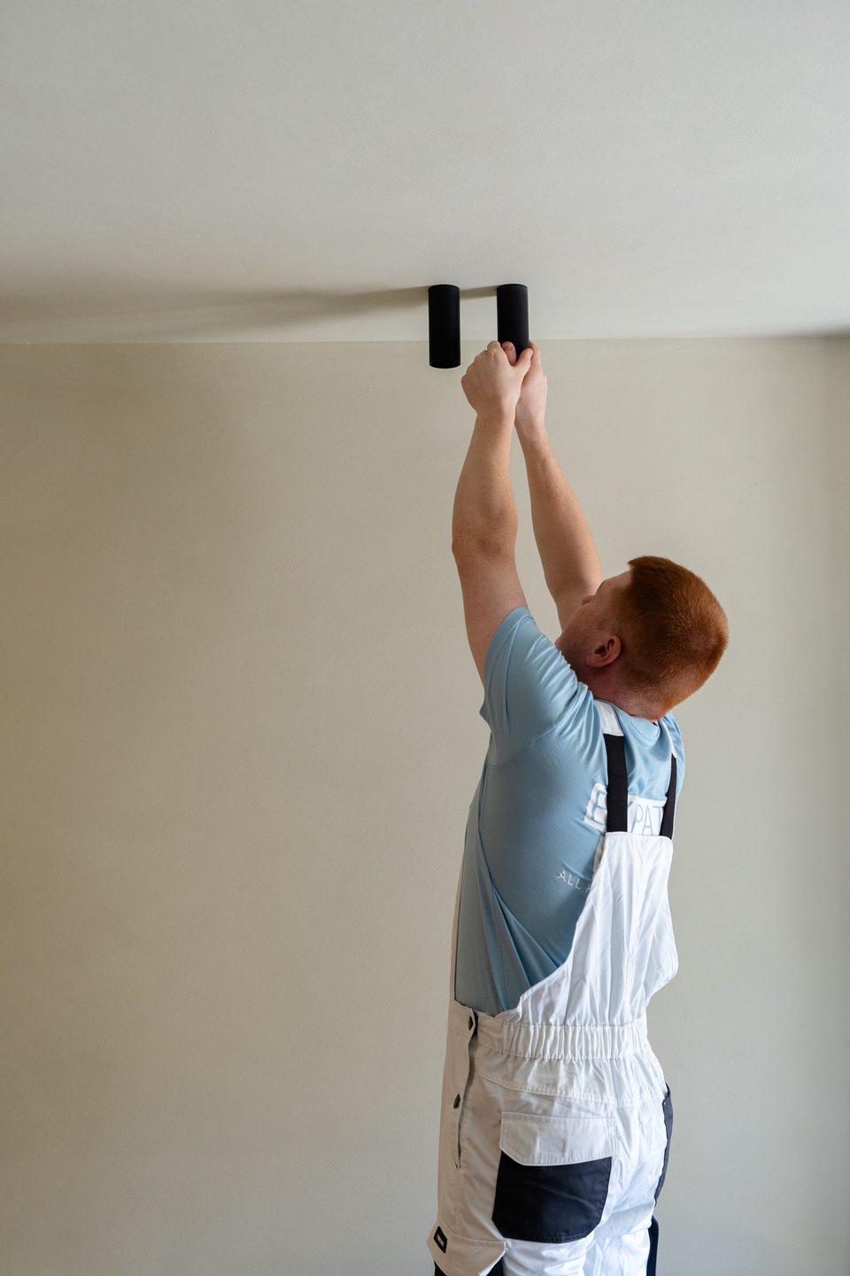 Expat Mates electrician installing a ceiling spotlight